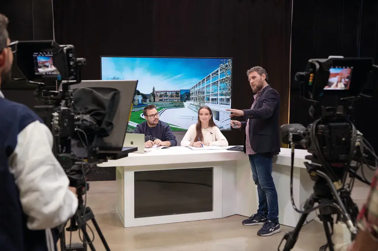 Presentadores discuten cu&aacute;nto dura la carrera de periodismo en un set de televisi&oacute;n, con c&aacute;maras y una pantalla de fondo.
