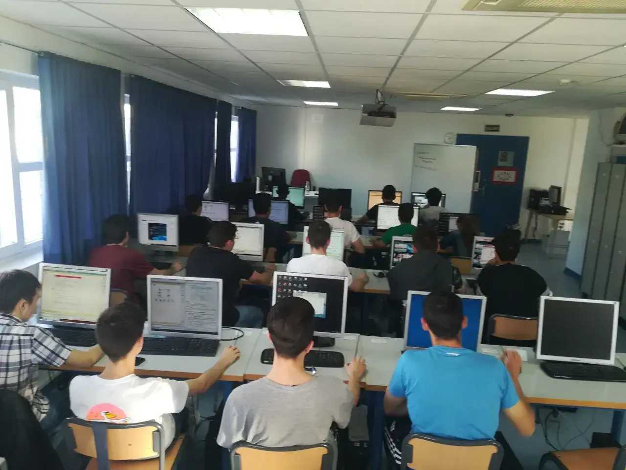Estudiantes de grado medio inform&aacute;tica concentrados frente a sus ordenadores en un aula.