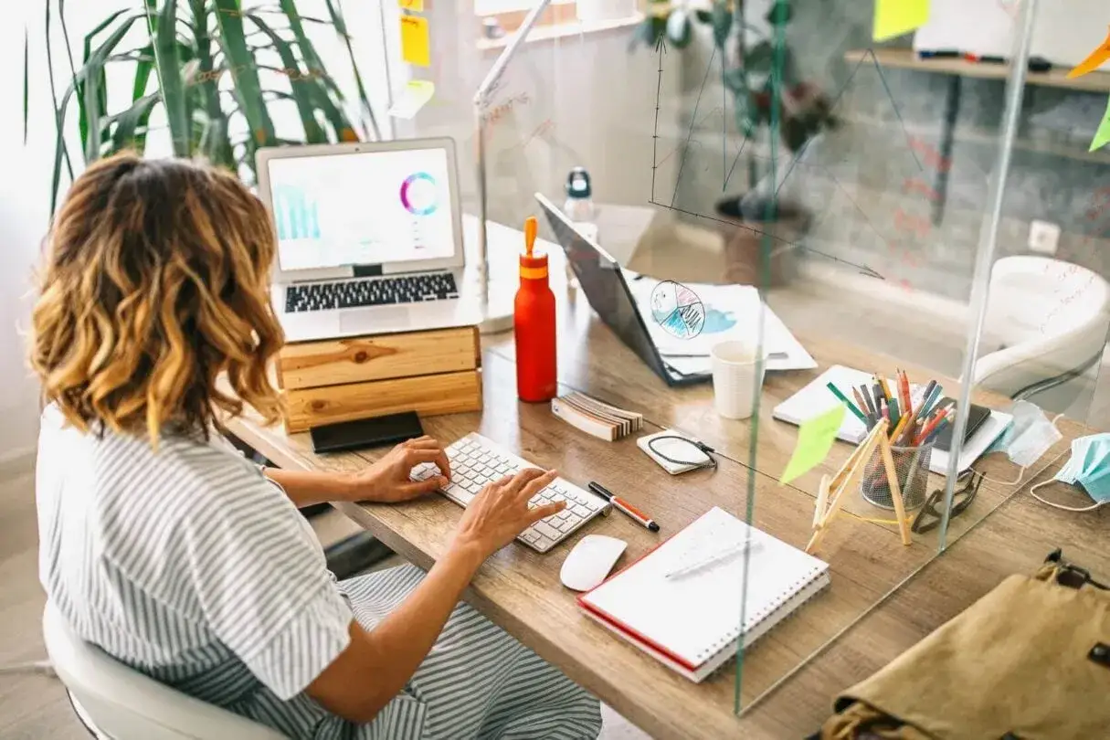 Mujer trabajando en su escritorio, analizando gr&aacute;ficos. El sueldo en negocios internacionales es prometedor.