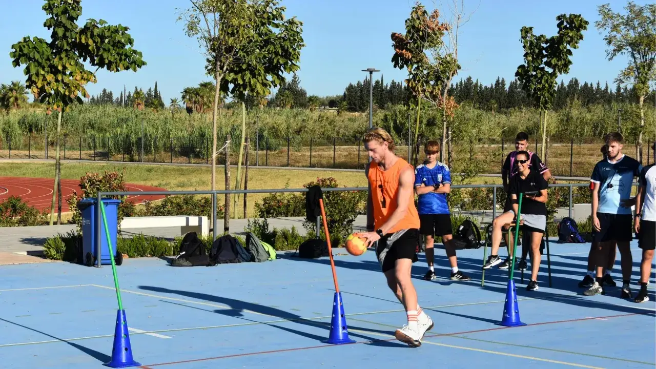 J&oacute;venes entrenan en una cancha deportiva al aire libre, un lugar ideal donde estudiar y practicar deportes.