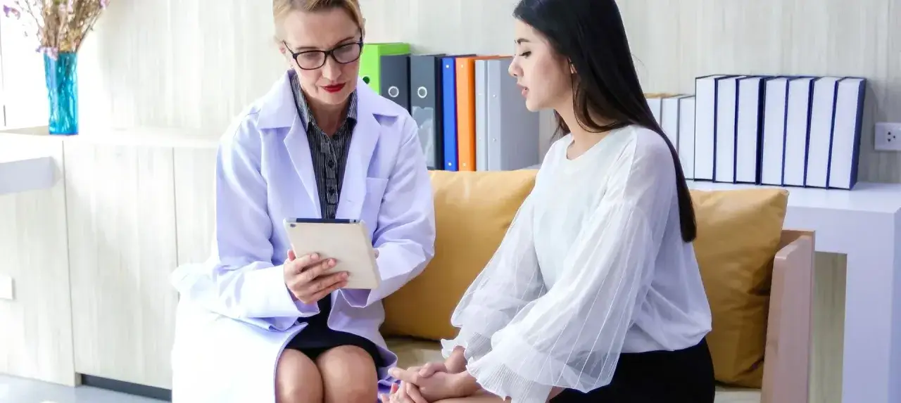 Profesional de est&eacute;tica en Espa&ntilde;a revisa tablet con paciente. Se discute cu&aacute;nto gana una esteticista en Espa&ntilde;a.