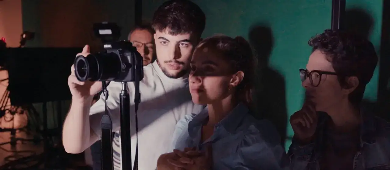 J&oacute;venes aprendiendo comunicaci&oacute;n audiovisual, con un chico operando una c&aacute;mara y otros observando.