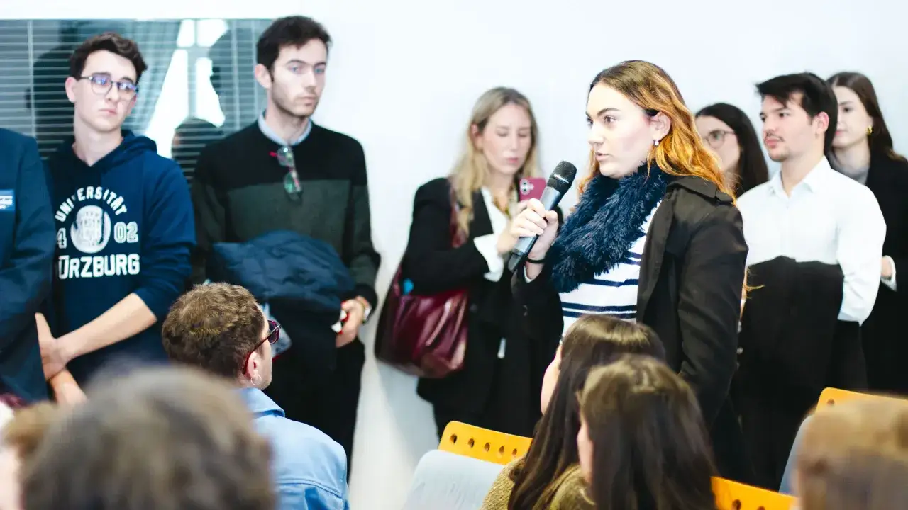 J&oacute;venes discuten sobre econom&iacute;a pol&iacute;tica en un evento.
