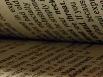 Páginas de un libro abierto, con texto en inglés. Se lee "old", "bad", "fashion", "throat", "around", "because", "often", "exp".